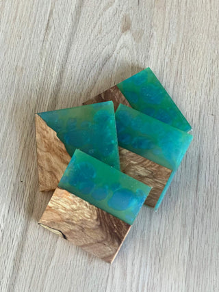 Wooden coasters with green resin on a light wooden surface