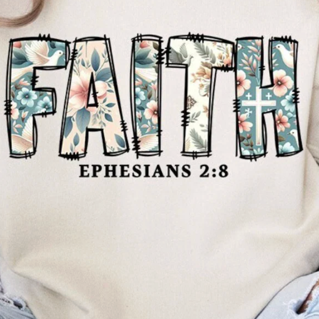 White sweatshirt with floral and cross design spelling 'FAITH' and 'Ephesians 2:8'