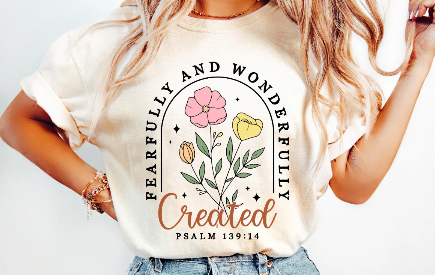 Person wearing a white t-shirt with floral design and text