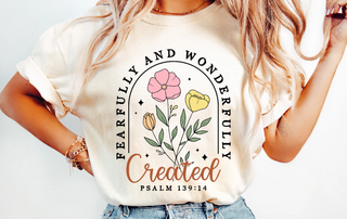 Person wearing a white t-shirt with floral design and text