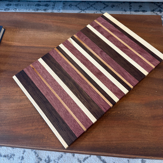 Wooden cutting board with striped pattern on a wooden surface