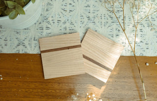 Two wooden coasters on a textured surface with a light background