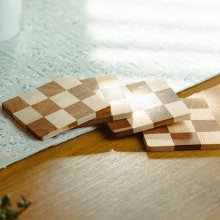 Wooden coasters with checkered pattern on a light wooden surface
