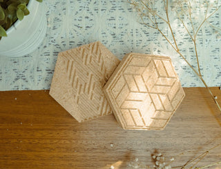 Hexagonal wooden coasters with a geometric pattern on a wooden surface.