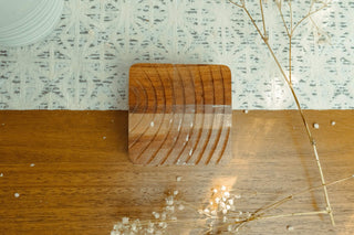 Wooden cutting board with a clear resin finish on a wooden surface with decorative elements.